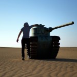 یک شخص مبهم که با دستاش یک تانک در صحرا نگهداشته