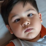 کودک ۴ساله چشم قهوه ای ابروهای کشیده موهای معمولی لخت رنگ بور که به طرف راست شانه شده بالای چشم راست یک خال 
لب ها معمولی  کوچک سیاه گونه متوسط