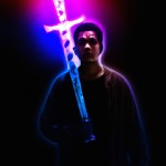 مردی که به دستش شمشیر گرفته و از پشت او نور می‌تابد و چهره مرد اسکلتی باشد و ترکیب های نوری و رنگی زیاد داخل تصویر باشد