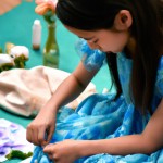 یک دختر در حال طراحی از گل با لباس ابی رنگ
