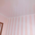 اتاق دخترانه ای که دیوارهای سفید دارد و فقط یک دیوار با خطوط صورتی کم رنگ راه راه شده است