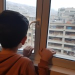 پسر ایرانی در خانه اتاق زیبا و از پنچره نمای شهر تهران
