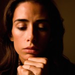 یک دختر بوکسور با موهای فر مشکی در حال فکر کردن