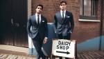 دو مرد کت شلواری خوش تیپ تمام قد زیبا که کنار تابلویی ایستاده اند که روش نوشته dairy-shop