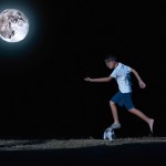 پسری زیبا در شب مشغول فوتبال بازی کردن در نور ماه است