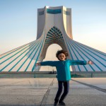یک کودک خوشحال جلوی برج ازادی تهران