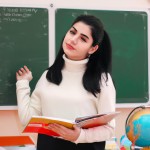 یک معلم دختر زیبای ایرانی 20 ساله در حال تدریس در کلاس درس
