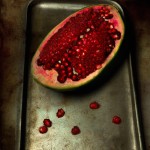 تصویر یک آنانکه یک چهارمش باز شده روی یک گاری قدیمی با هندوانه دانه های انار مثل یاقوت بدرخشه