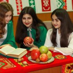 چند دختر نوجوان در یک مدرسه در شب یلدا با انار و هندوانه و کتاب فال حافظ و پرچم ایران