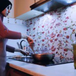 تصویر یک زن ایرانی در حال پخت غذا در آشپزخانه