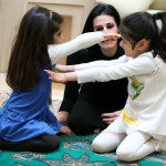 یک دخترخانم ایرانی در خانه در کنار خانواده 5 نفره در حال بازی کردن