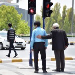 پلیس ایرانی در حال کمک به یک پیرمرد برای عبور از خیابان