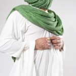 یک مرد مسلمان با لباس سفید عربی شال سبز دور کمر چهره زیبا با ریش عمامه سبز